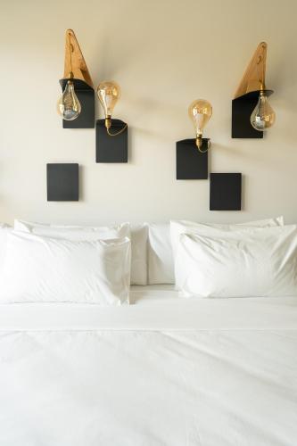 a bedroom with a white bed with lights on the wall at B&B Panevì in San Marcello