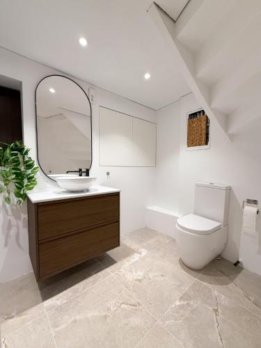 a bathroom with a sink and a toilet and a mirror at Soft Stay Apartment in Bergen