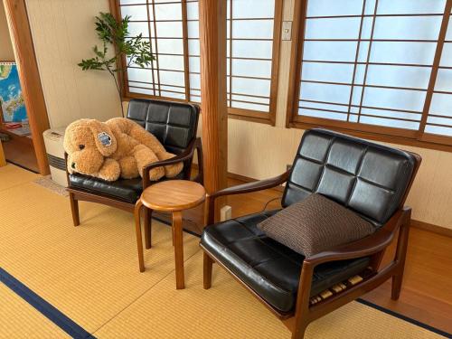 a stuffed teddy bear sitting in two chairs and a chair at 三ツ和のお宿 in Nakano