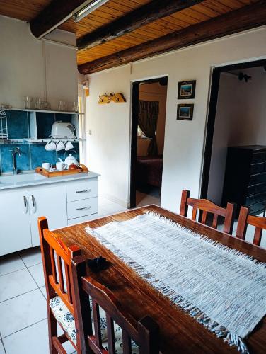 a kitchen with a wooden table and chairs in it at Nuestro Lugar in El Bolsón