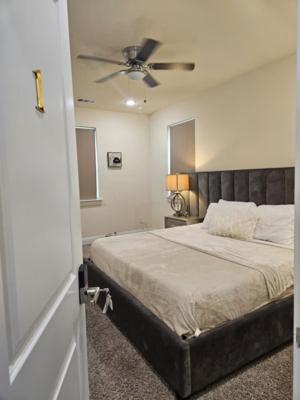 ein Schlafzimmer mit einem Bett mit Deckenventilator in der Unterkunft Downtown Access • Fenced Yard • Sleeps 10 in McKinney