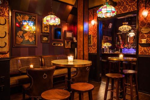 a bar with two tables and chairs and chandeliers at The Rosemary in Los Angeles