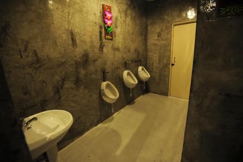 ein Badezimmer mit drei Urinalen und einem Waschbecken in der Unterkunft Twin Palms Hostel Phi Phi in Ko Phi Phi