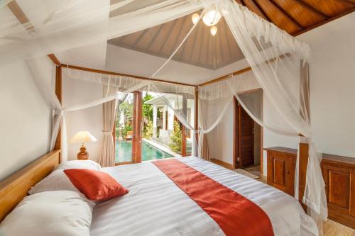 a bedroom with a large bed with a canopy at Villa Pantina Bali in Uluwatu