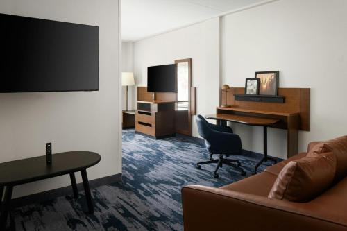 a hotel room with a couch and a desk at Fairfield Inn & Suites by Marriott Newark Liberty International Airport in Newark