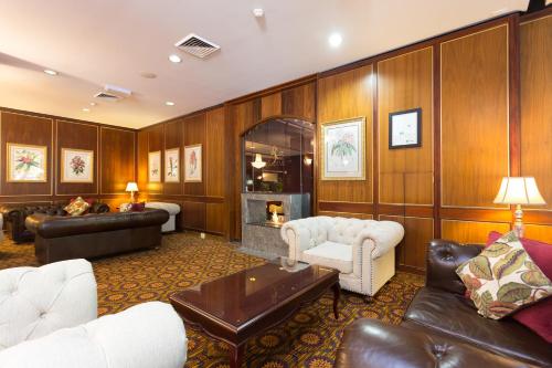 a living room with leather furniture and a fireplace at Royal On The Park in Brisbane