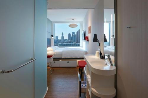 a bedroom with a bed and a sink and a mirror at citizenM Boston North Station in Boston