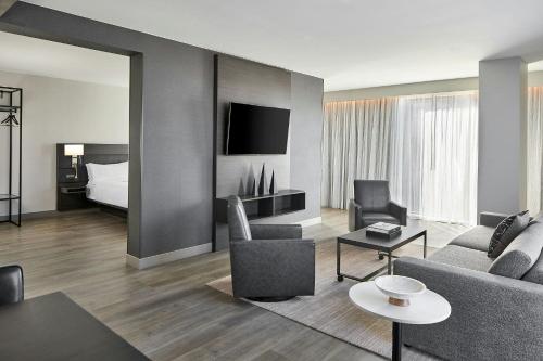 a living room with a couch and a bed at AC Hotel by Marriott Auburn in Auburn