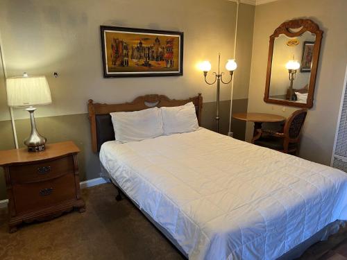 a bedroom with a bed and a table and a mirror at Lariat Motel in Sparks