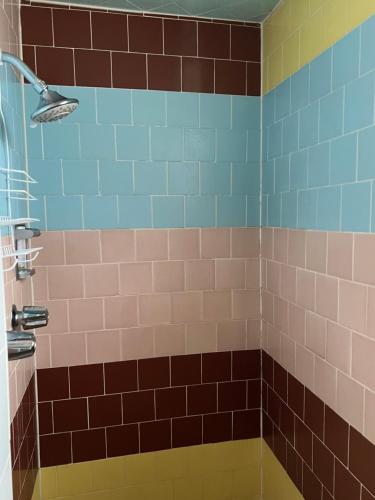 a bathroom with brown and blue tiles and a shower at Lariat Motel in Sparks
