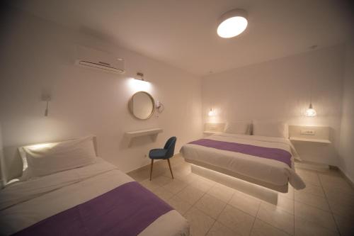 een hotelkamer met twee bedden en een stoel bij Markakis Studios Fira Town in Fira