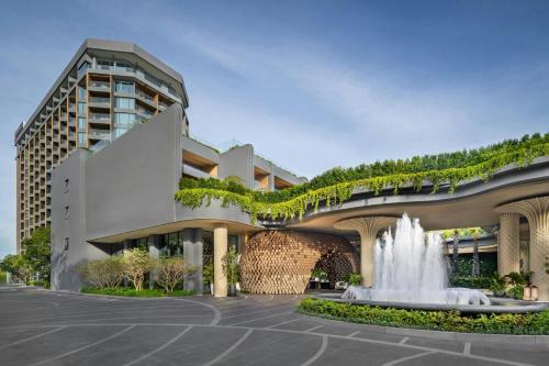 a building with a fountain in front of a building at Pattaya Marriott Resort and Spa in Jomtien Beach