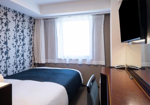 Una habitación de hotel con una cama y una ventana. en APA Hotel Haneda Anamori Inari Ekimae, en Tokio