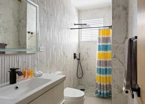 a bathroom with a sink and a toilet and a shower curtain at Ocean Park 3BDR 2b Hot tub-Terrace Riviera Villa in San Juan