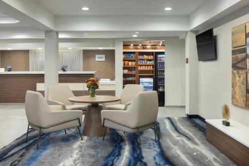 a lobby with a table and chairs and a library at Fairfield Inn & Suites Jacksonville Airport in Jacksonville