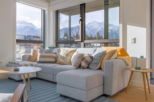 a living room with a couch and some windows at Cedar Vista - condo with stunning mountain views in Revelstoke