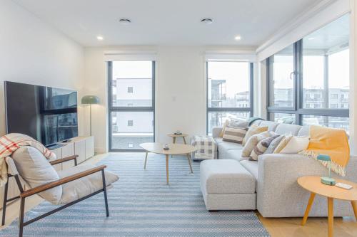 a living room with a couch and a tv at Cedar Vista - condo with stunning mountain views in Revelstoke