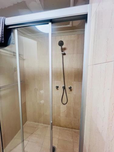 a shower with a shower head in a bathroom at Pavilion Hotel Wagga Wagga in Wagga Wagga