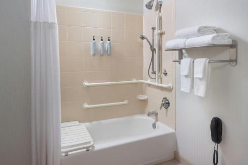 a bathroom with a shower and a white tub at Courtyard by Marriott Birmingham Downtown at UAB in Birmingham
