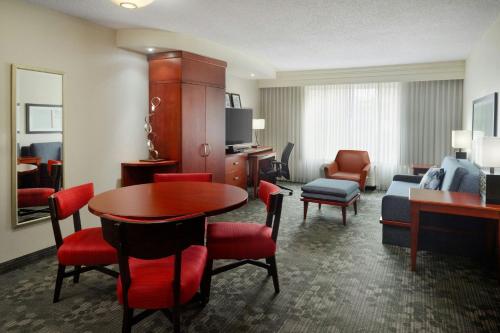 a hotel room with a table and chairs and a living room at Courtyard by Marriott Birmingham Downtown at UAB in Birmingham