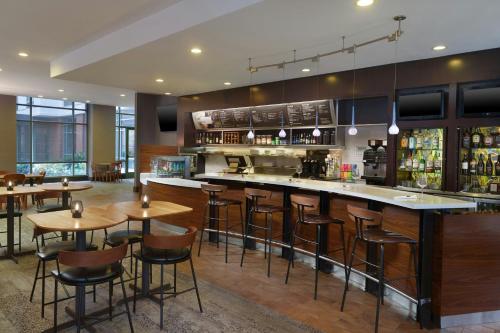 a bar in a restaurant with wooden tables and bar stools at Courtyard by Marriott Birmingham Downtown at UAB in Birmingham