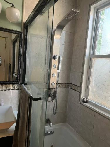 a bathroom with a shower with a glass door at Casa Castor • Private Room 2 in Chelsea