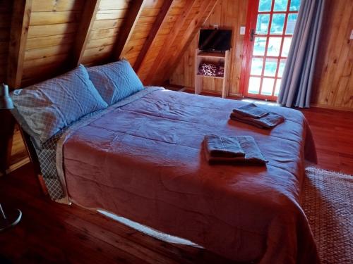 a bedroom with a large bed in a cabin at Refúgio Serrano - Cabana in São Francisco de Paula