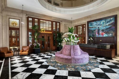 a lobby with a purple couch on a checkered floor at The Edinburgh Grand, a Luxury Collection Hotel, Edinburgh in Edinburgh