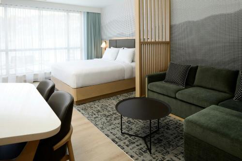een hotelkamer met een bed, een bank en een tafel bij Residence Inn by Marriott Bromont in Bromont