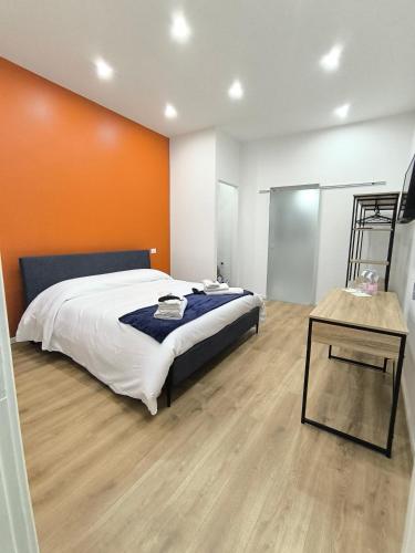 a bedroom with a large bed with an orange wall at Casa con vista in Ariccia