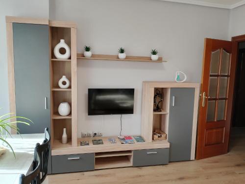een woonkamer met een entertainmentcentrum met een flatscreen-tv bij La Esperanza in Teruel