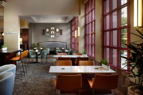 a restaurant with tables and chairs and windows at Atlanta Marriott Suites Midtown in Atlanta