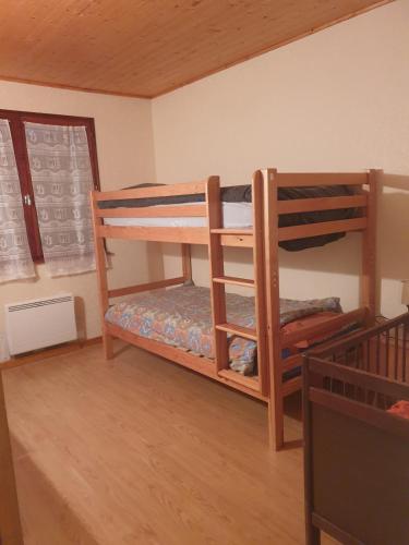 a bedroom with two bunk beds in a room at Logement du Bois de Chaubon in Fillinges