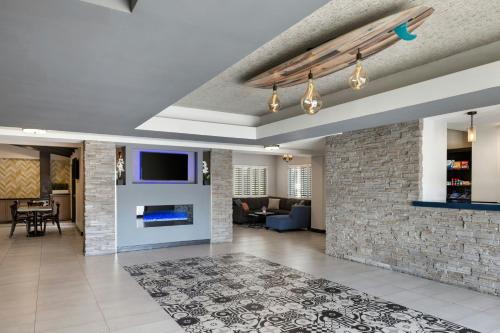 a living room with a fireplace and a tv at City Express by Marriott Manhattan Beach in Manhattan Beach