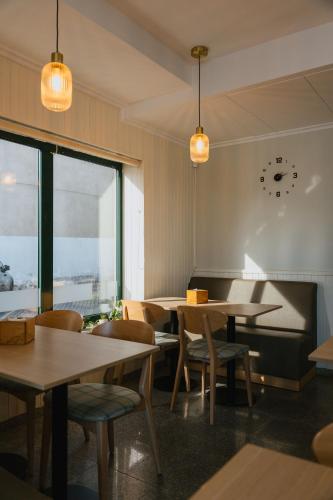a restaurant with tables and chairs and a large window at Hotel O Encontro in Sendim