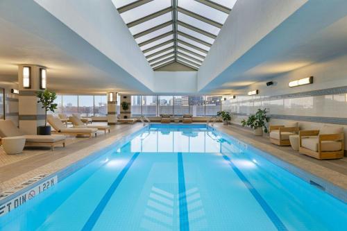 a large swimming pool with furniture and a building at The Westin Jersey City Newport in Jersey City
