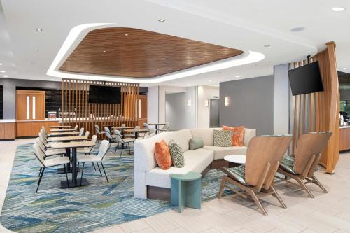 una hall con un divano, tavoli e sedie di SpringHill Suites Pigeon Forge a Pigeon Forge
