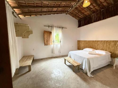 a bedroom with a white bed and a window at Anahi Caraiva in Caraíva