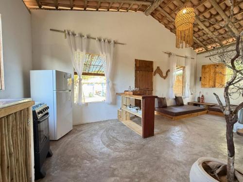 a kitchen with a refrigerator and a table in a room at Anahi Caraiva in Caraíva