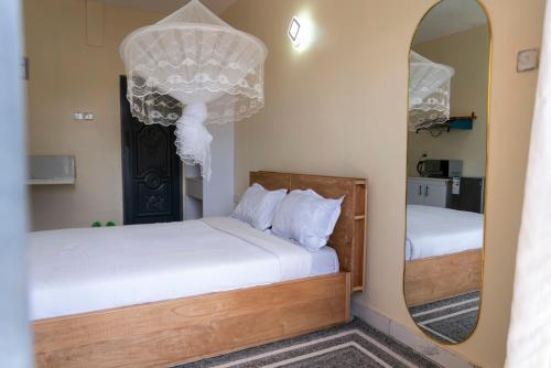 a bedroom with two beds and a mirror at Exactly one minute away from Victoria Mall in Entebbe