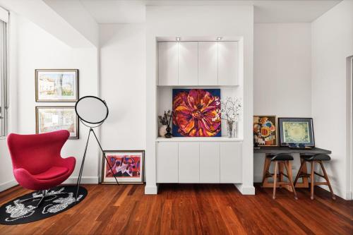 a living room with a red chair and a table at Artistic Opera House Retreat - Entire Apartment - 5-Min Ferry to CBD in Sydney