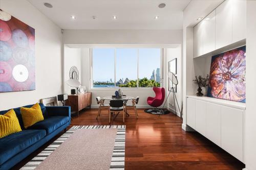 a living room with a blue couch and a table at Artistic Opera House Retreat - Entire Apartment - 5-Min Ferry to CBD in Sydney