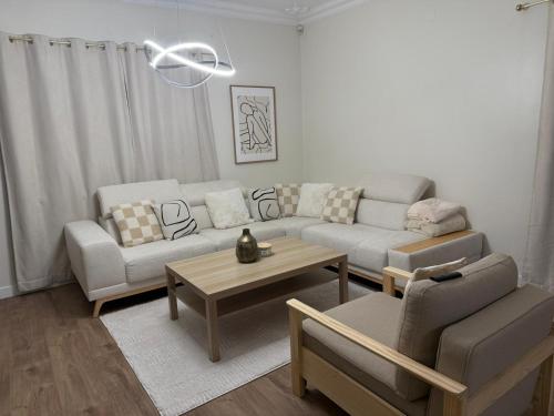 een woonkamer met een bank en een tafel bij The quinta in Quinta do Conde