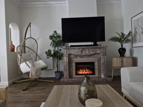 een woonkamer met een open haard en een flatscreen-tv bij The quinta in Quinta do Conde