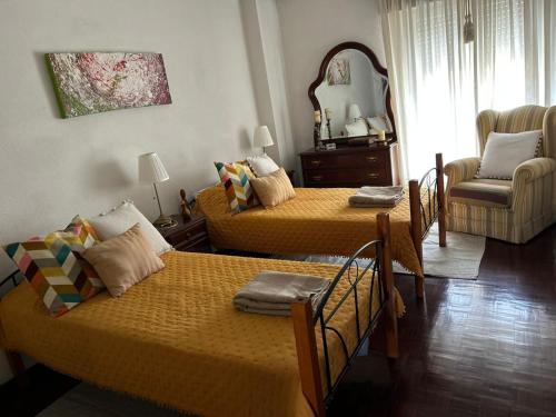 a living room with two beds and a chair at Blue House in Santiago do Cacém