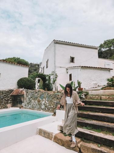 una donna in piedi sui gradini davanti a una casa di Casa Om a Dosríus