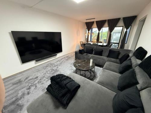 un soggiorno con divano e TV a schermo piatto di Spacious Cosy Apartment a Søborg