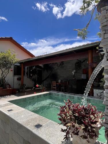 a swimming pool with a fountain in a yard at Villas House in Pirenópolis