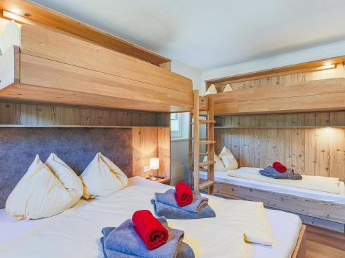 2 Etagenbetten mit roten Hüten darüber in der Unterkunft Krammer XL in Neukirchen am Großvenediger