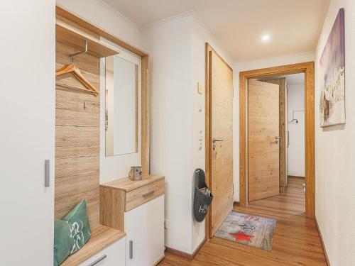 einen Flur mit Tür zu einem Zimmer mit Holzböden in der Unterkunft Krammer XL in Neukirchen am Großvenediger